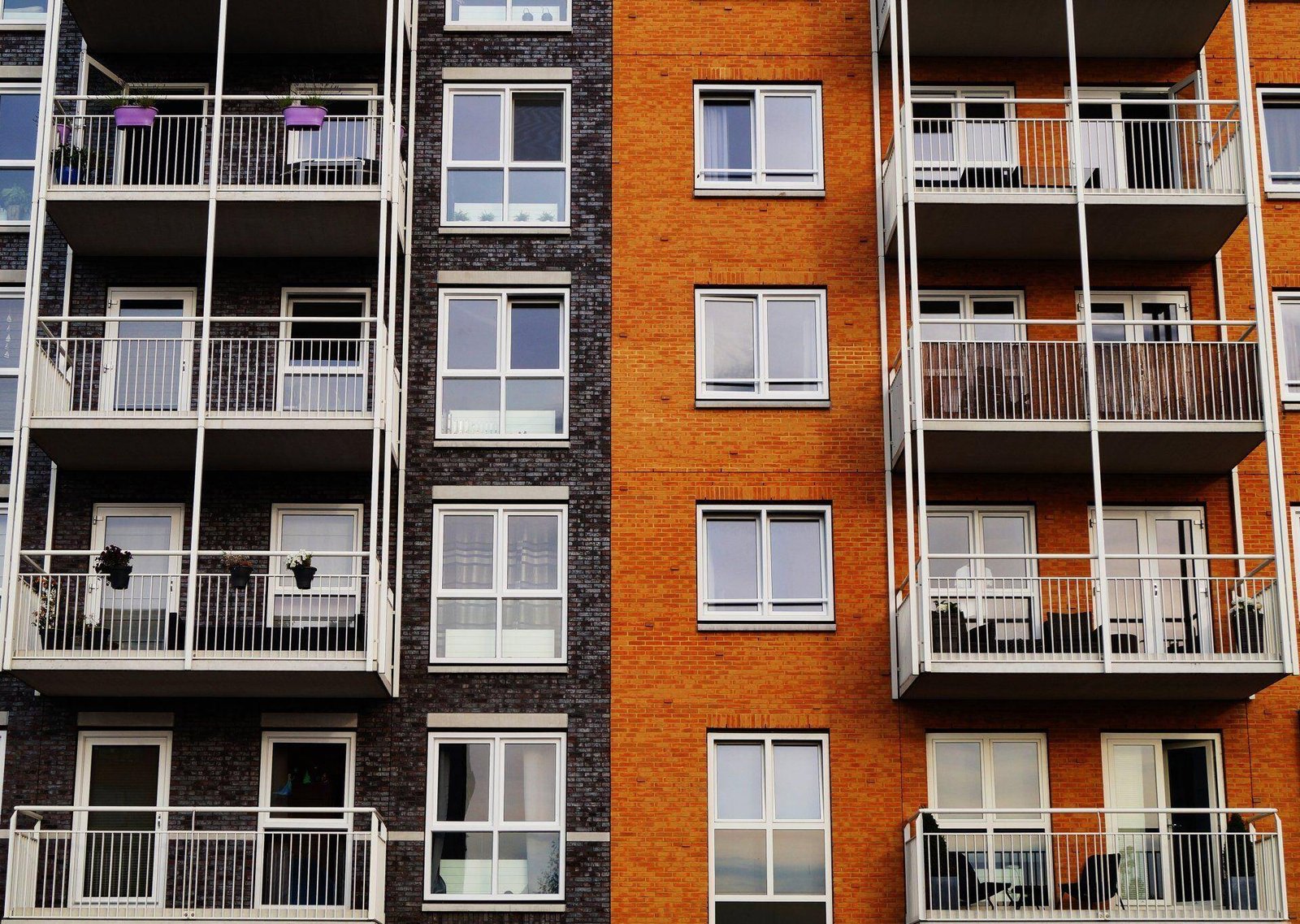 Apartment building exterior with brick walls, windows, and balconies.