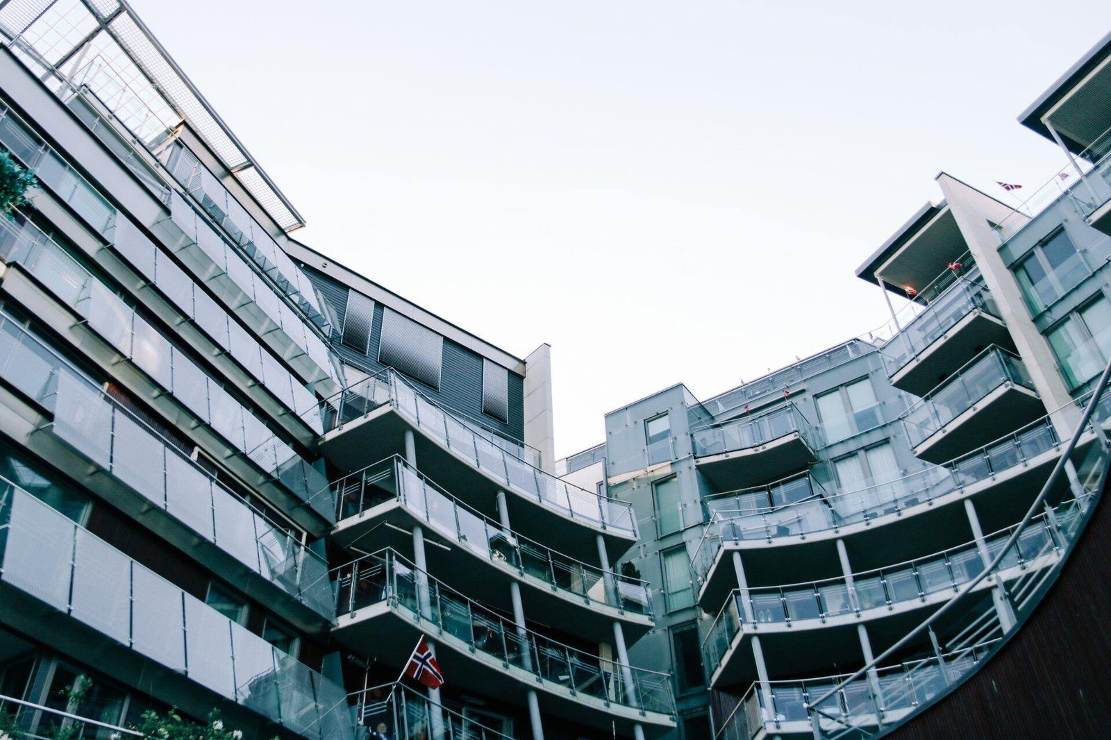 Low-angle view of glass commercial buildings and balconies.