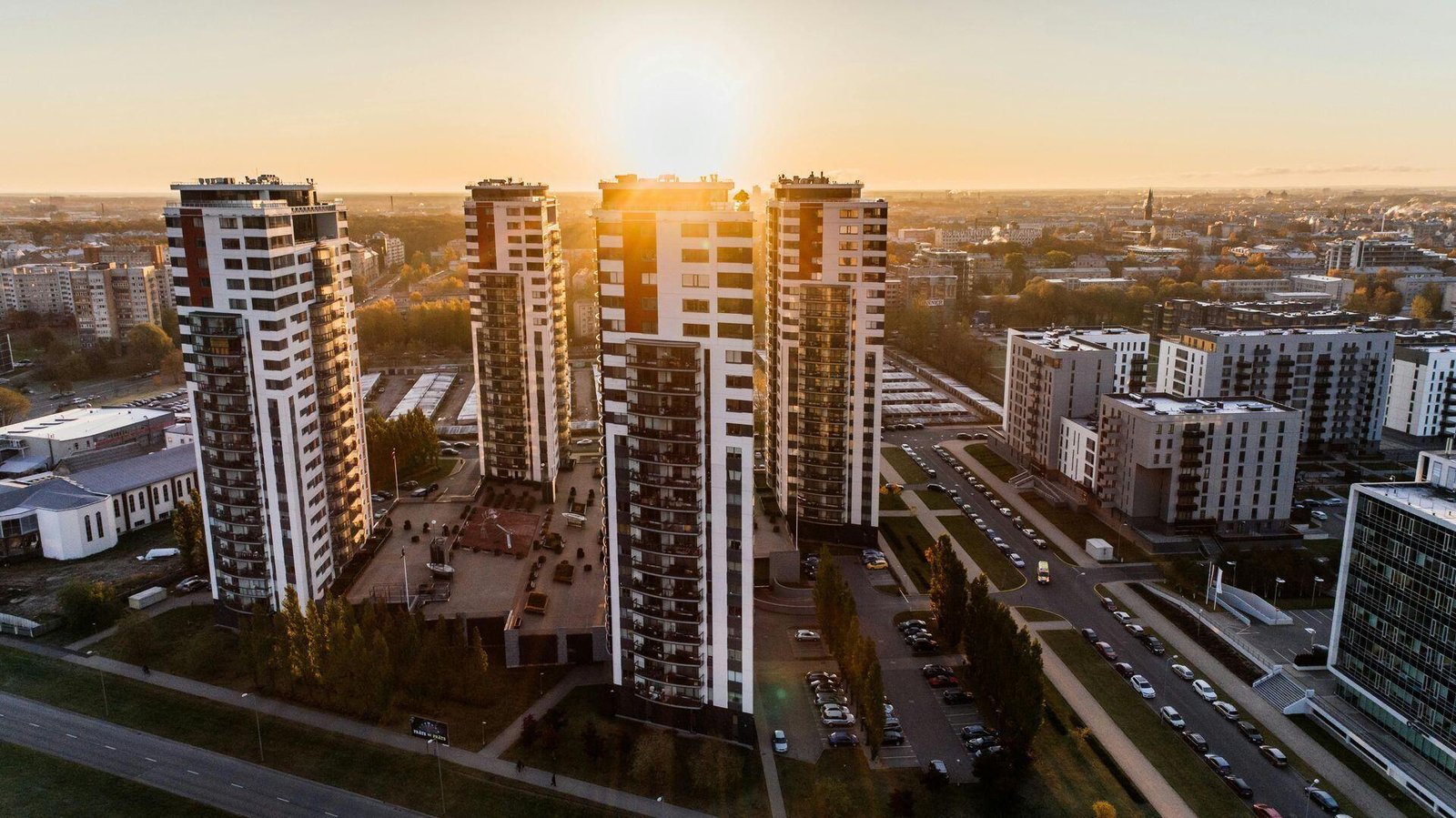 Apartment towers and surrounding city buildings viewed from above at sunset.