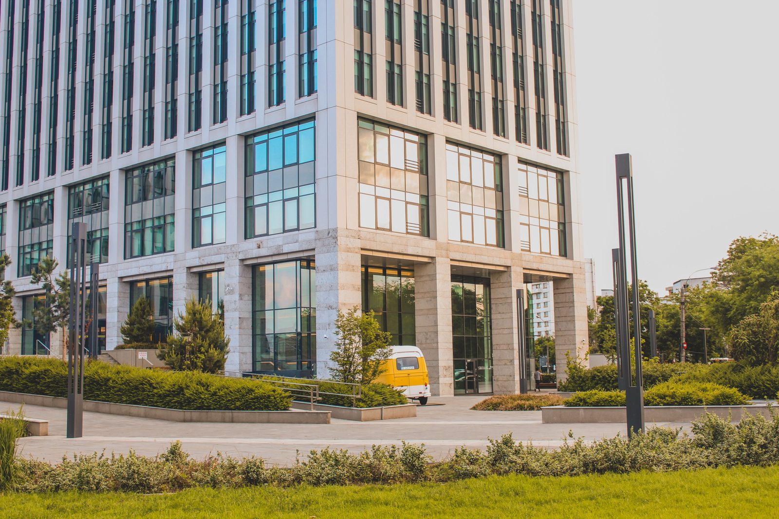 Contemporary commercial office building with a glass facade and landscaped frontage.
